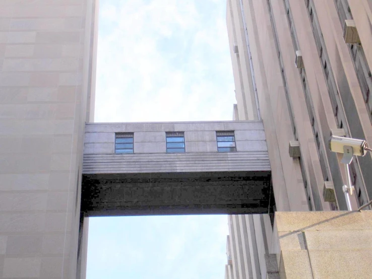 a long bridge going over a tall building on a sunny day