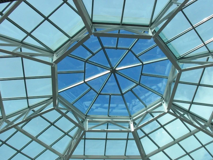 the glass roof of an indoor restaurant with blue skies