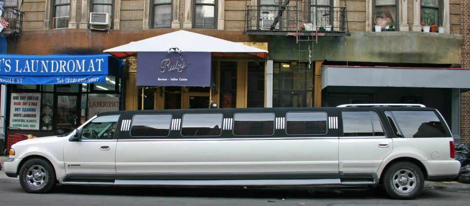 a limo is parked in front of a tall building