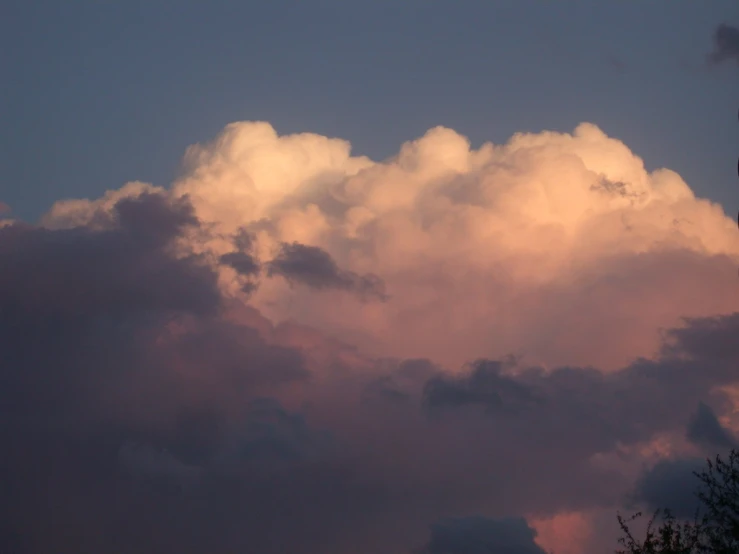 the sky is filled with white clouds and pink hues