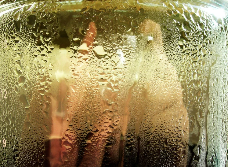 a very close up view of a vase with some water on the window sill