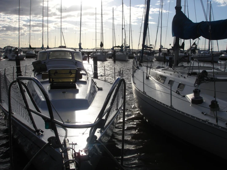 the sun shining on sailboats at sea in harbor