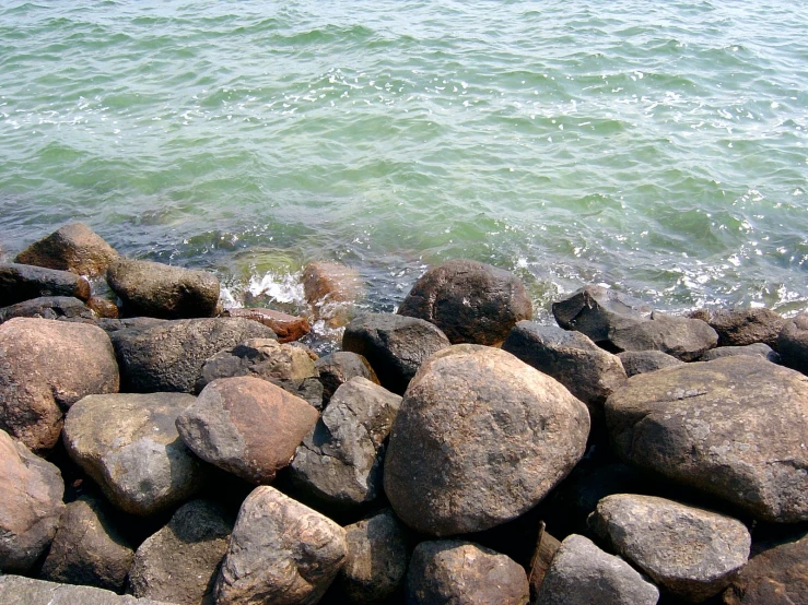 rocks stacked on to the shore near the water
