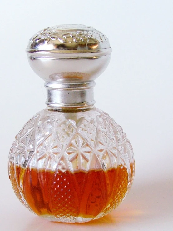 a crystal bottle with an ornate filigree on top