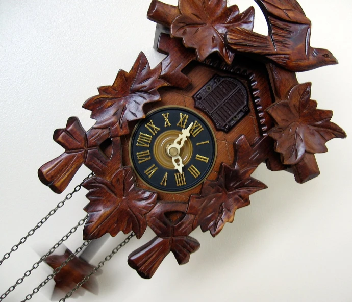 an antique wooden cuckoo clock made to look like fall leaves