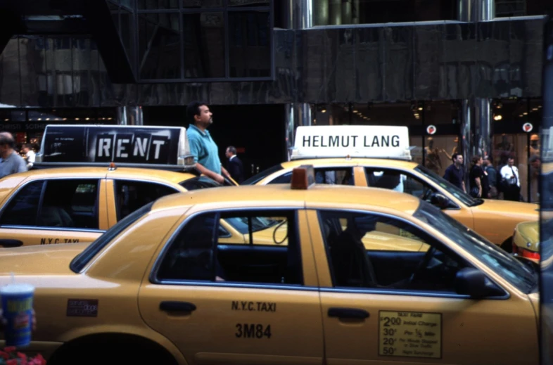 a yellow cab waiting to cross the street with a protest sign on top