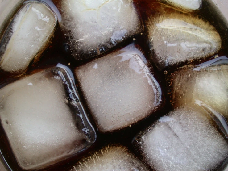 a group of ice cubes sit in an iced beverage