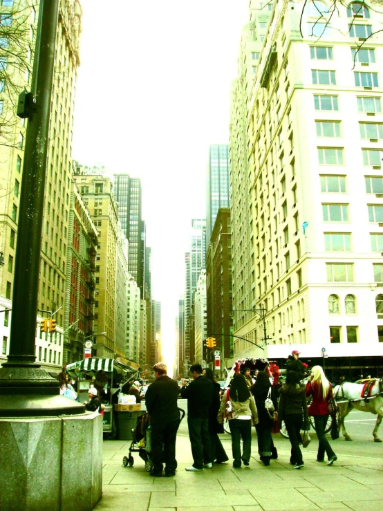 a crowd of people walk down a city street