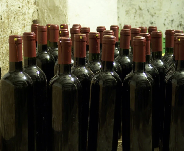 a bunch of black bottles sitting on top of a wooden floor