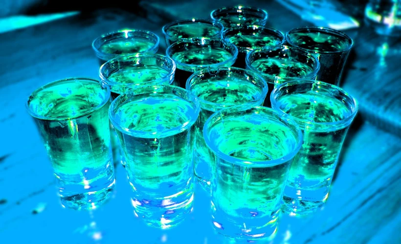 an array of s glasses on a table, with blue tinted light