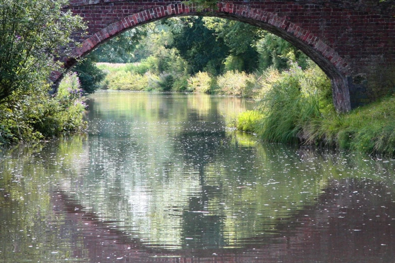 an arched brick bridge spanning over a river