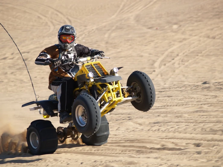 a person in a black and yellow suit is riding on a toy car