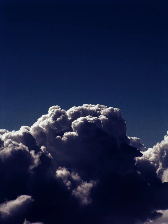 an airplane flying above fluffy clouds in the sky