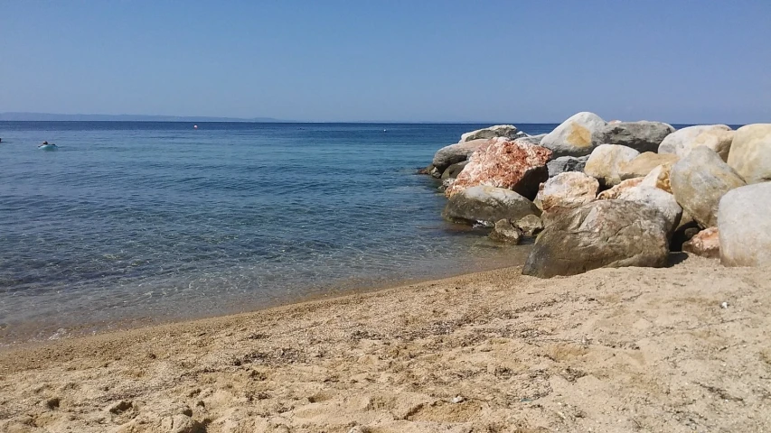 a rocky beach with rocks sticking out of the water