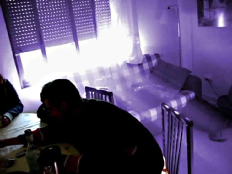 a man and woman sitting at a table in a dark room