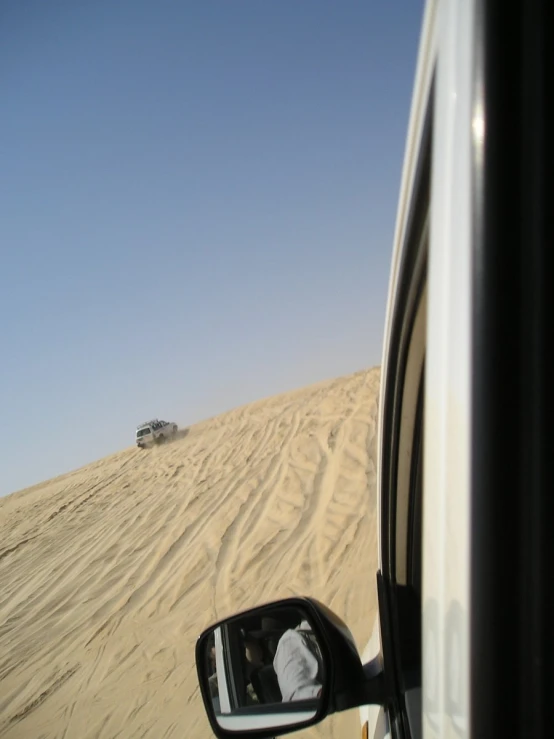 the view out of the vehicle window of a car in a desert