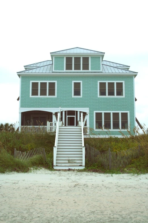 a beach house near the ocean with a large stairway leading to it