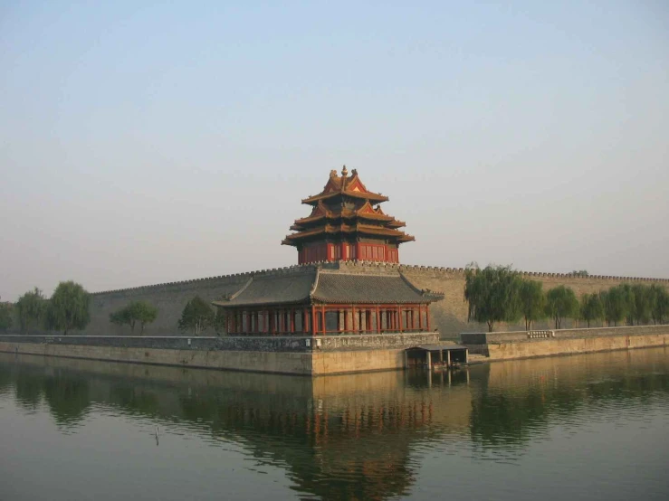a pagoda on top of a lake with trees