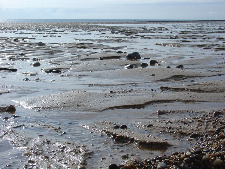 a rock pile on a beach with water