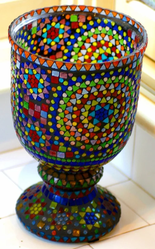 a colorful glass sitting on top of a white tile floor