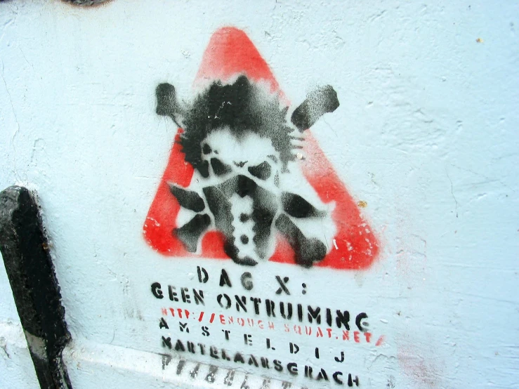 graffiti depicting a cow and a triangle on a white wall