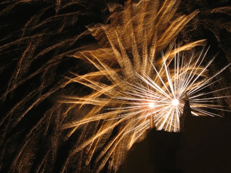 an array of fireworks and smoke explodes against a black background