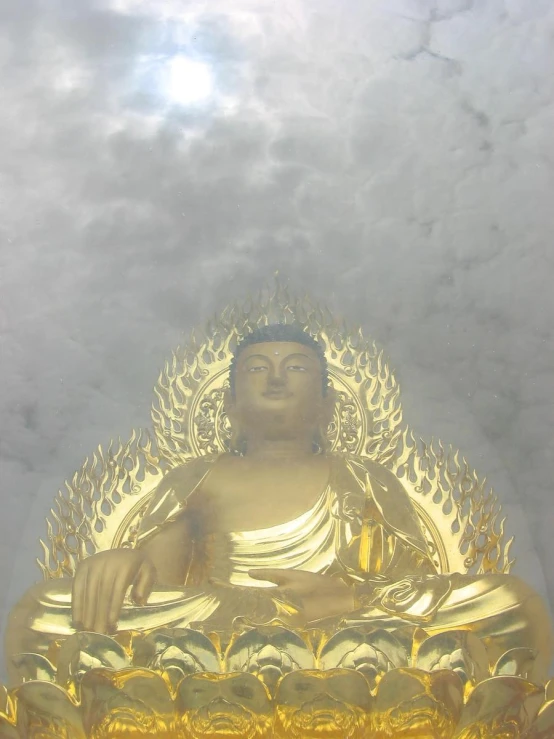 buddha statue in front of cloudy skies with a few sunlit clouds