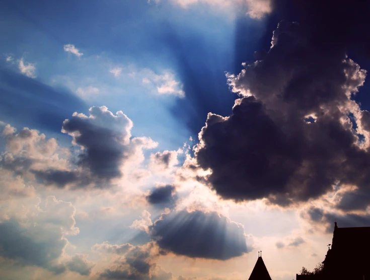 a building silhouetted by the rays of a setting sun