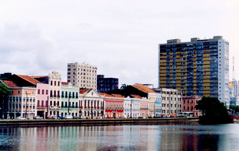 an old - looking river runs past a row of high rise buildings