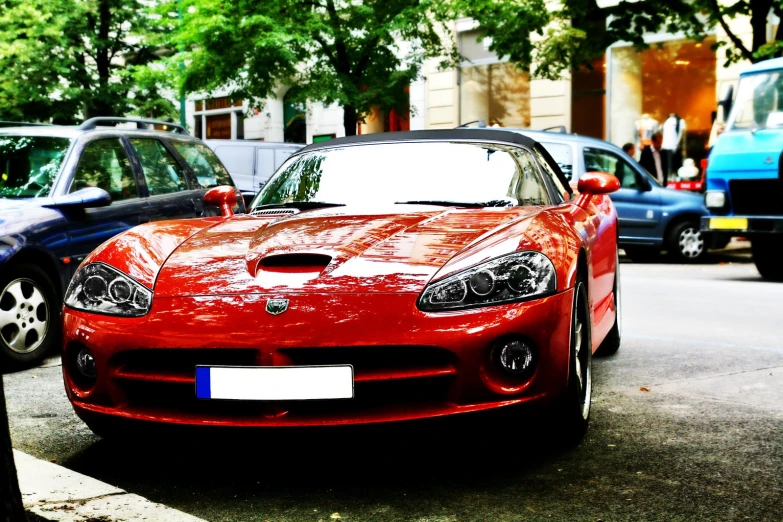 the red sports car is parked in front of a blue and black one