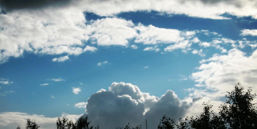 a cloud filled sky over some trees