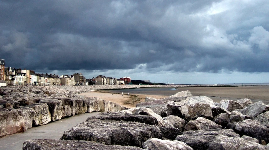 a very stormy sky is above some stone formations