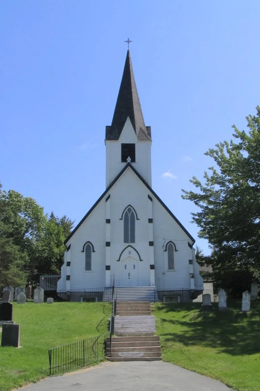 the large white church is by itself on a sunny day