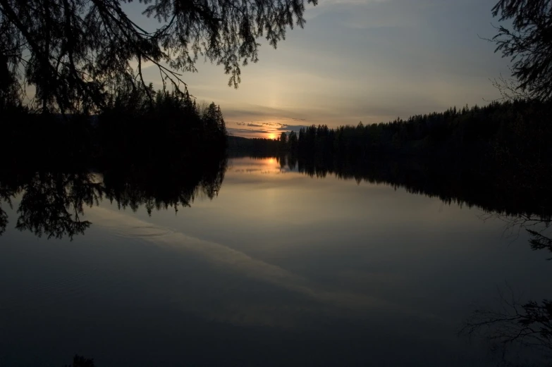 a lake is pictured at sunset during the evening