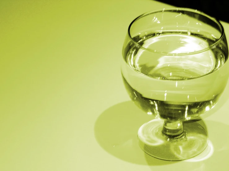 a glass of water sitting on top of a white table