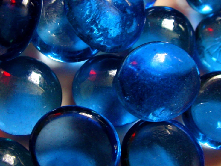 blue glass beads are arranged together on a table