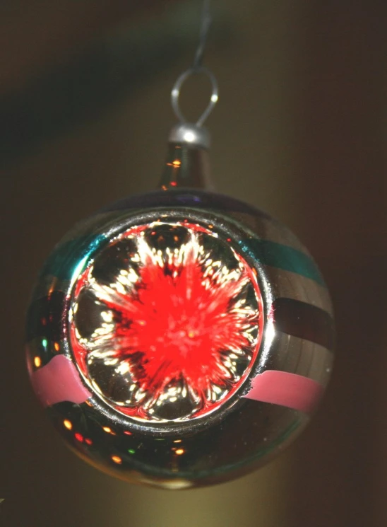 this is a circular glass ornament with bright red stars