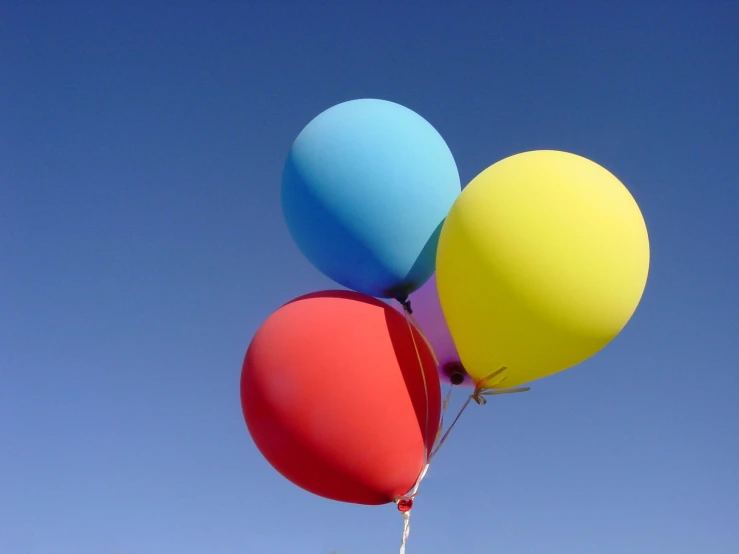 a bunch of balloons are floating in the air