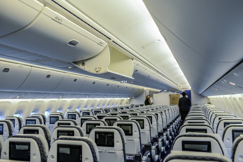 rows of empty seats inside a large commercial airplane