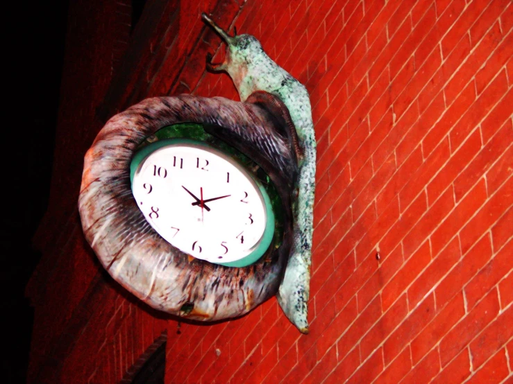 an animal clock mounted on the side of a brick building