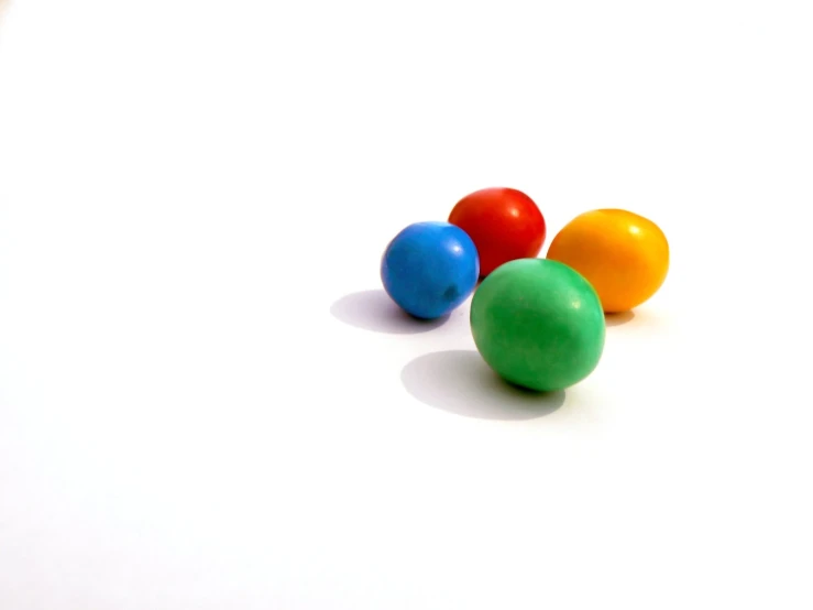 small colorful candies lying on a white surface