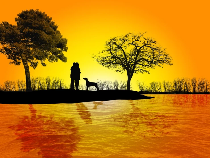 silhouette of two people and a dog standing on a shore of water