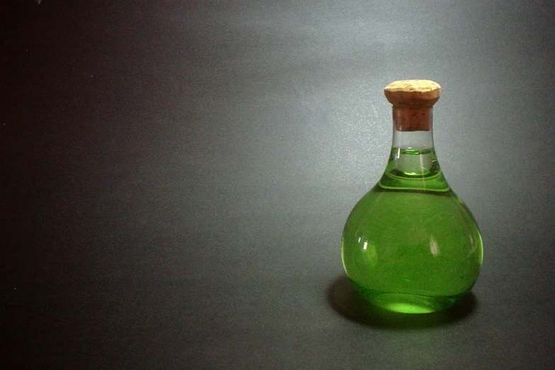 a green glass bottle with cork stop on top