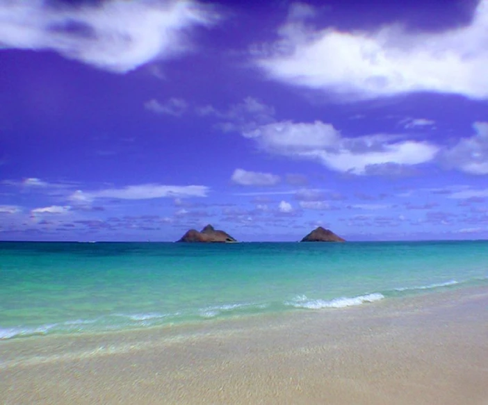 there are two mountains at the beach in the ocean