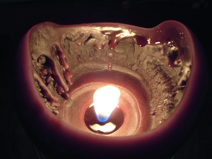 a candle lit inside of a decorative bowl