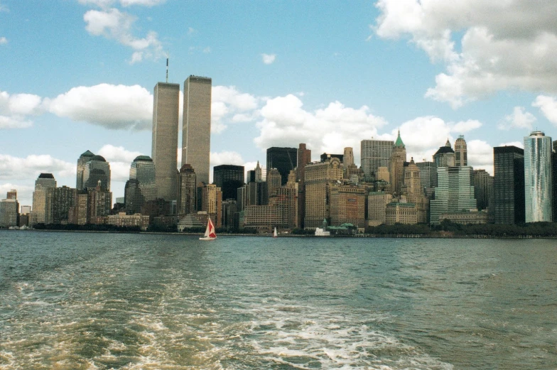 the boats are sailing in the harbor near the tall city buildings