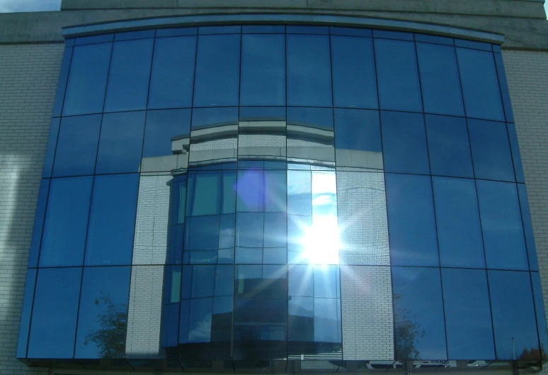 the sun shines brightly in the windows of this office building