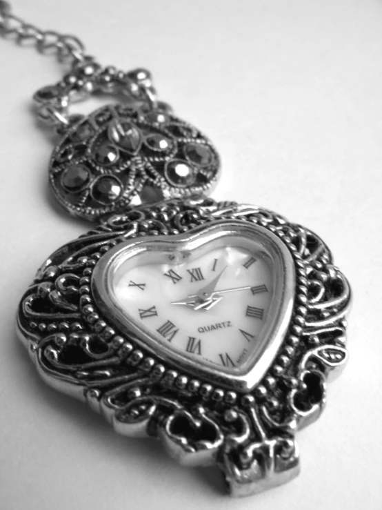 a heart shaped watch with a chain hanging from it