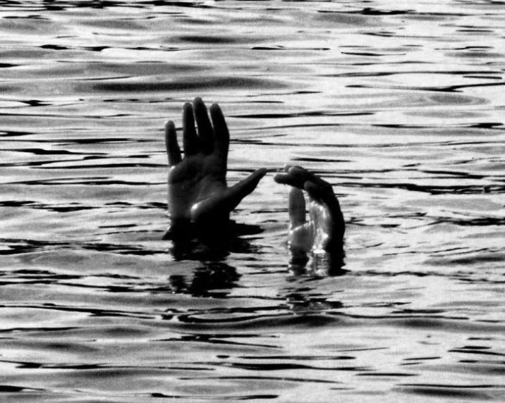 two hands reaching out into the water