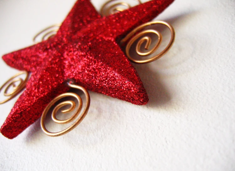 a close up image of red glitter star shaped pin